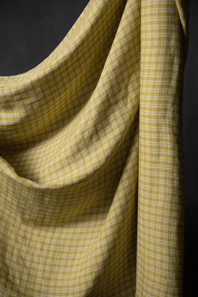 Close-up of yellow checkered fabric against a dark background