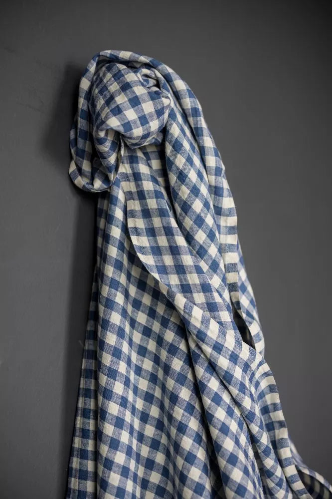 Blue and white checkered fabric draped over a gray surface