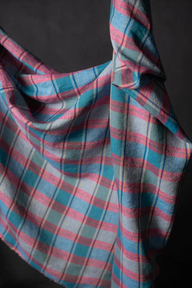 Plaid fabric with pink and blue stripes on a dark background