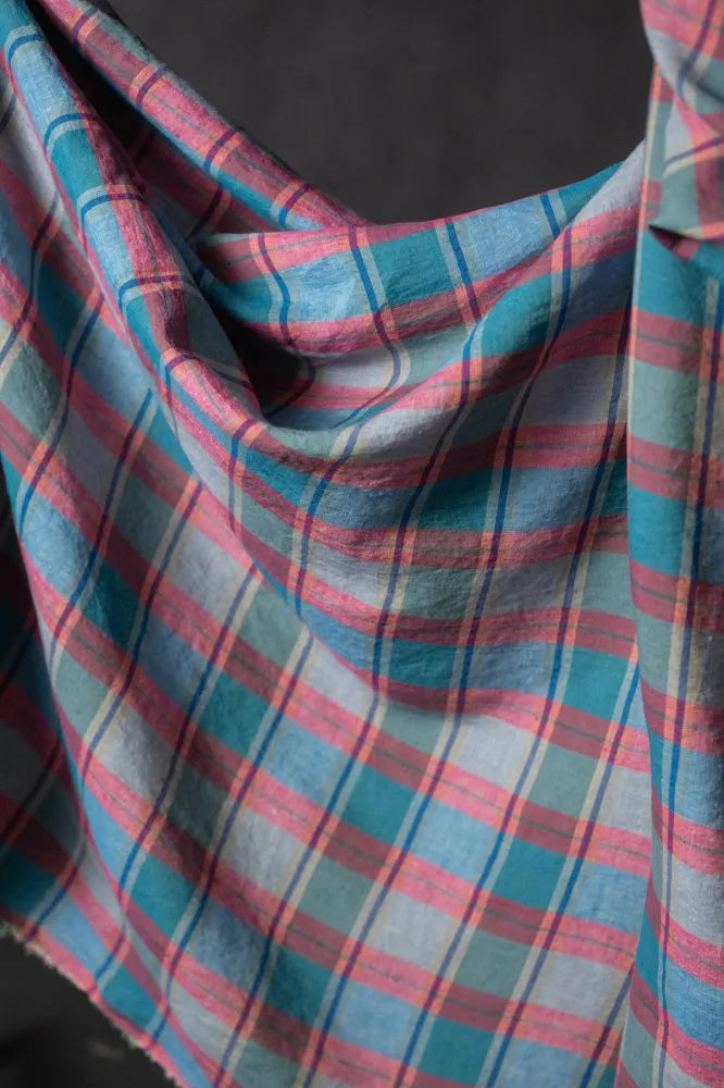 Plaid fabric with blue and pink stripes on a dark background