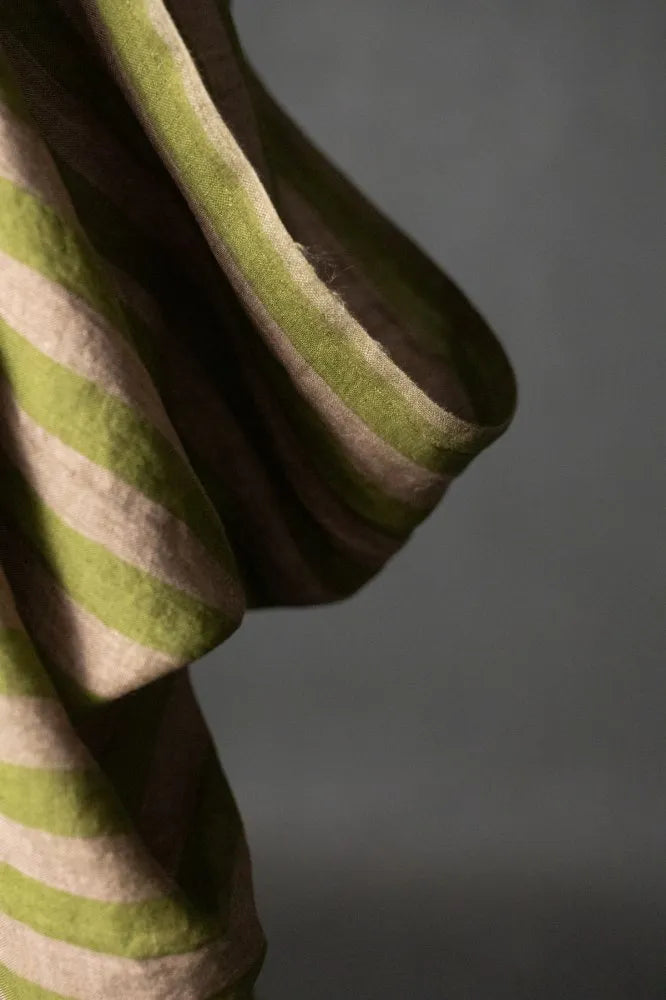 A muted green and pale pink striped linen fabric